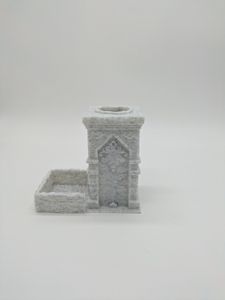 A smaller 3D printed dice tower. It looks like a square, flat roofed tower, and it's printed in a marble-like filament. This is a side view of it.