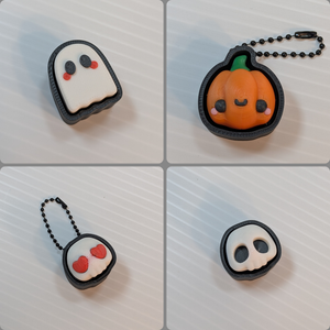 A photo in four parts, each showing a 3D printed clicker. It goes from the top left, clockwise: Ghost, Pumpkin, Heart Skull, and Skull. Better descriptions for each clicker will be on their individual photos.