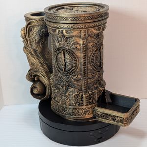A "tankard" that acts as a dice tower, dice vault, and can holder. It's in a brass rub n buff, and it's fully assembled, with the dice vault inside and cap on top.