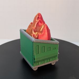 A back view of the small 3D printed dumpster fire, with the dumpster in green with silver trim. The flames are red and yellow, and this rear angle does a nice job of showing the shift in colors.
