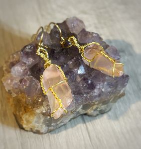 Earrings displayed on a piece of Amethyst.