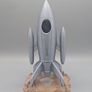 The back of the dice tower, showing the hole where the dice go in towards the top, just under the conical tip of the rocket.