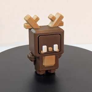 A 3D printed reindeer. it's brown, with a tan spot on its chest and tan antlers, white eyes, and tan nose and cheeks. It's modeled very much like an 8 bit video game character.