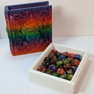 The tome sitting upright next to the pages, fully slid out and laying flat. The pages are filled with dice, approximately 25, and you can see the rails on the side. You can see the top magnet in the tome's top right corner, inside.