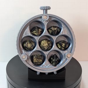 The box with the lid and levers removed. It shows spaces for a standard 7-piece set of TTRPG dice, and magnets that hold the lid on.