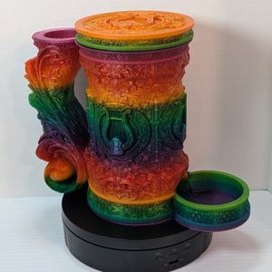 A "tankard" that acts as a dice tower, dice vault, and can holder. It's in a bright rainbow gradient, and it's assembled to show how it all goes together.
