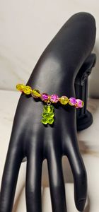 Purple and green beads paired with a gummy bear that compliments the bracelet.