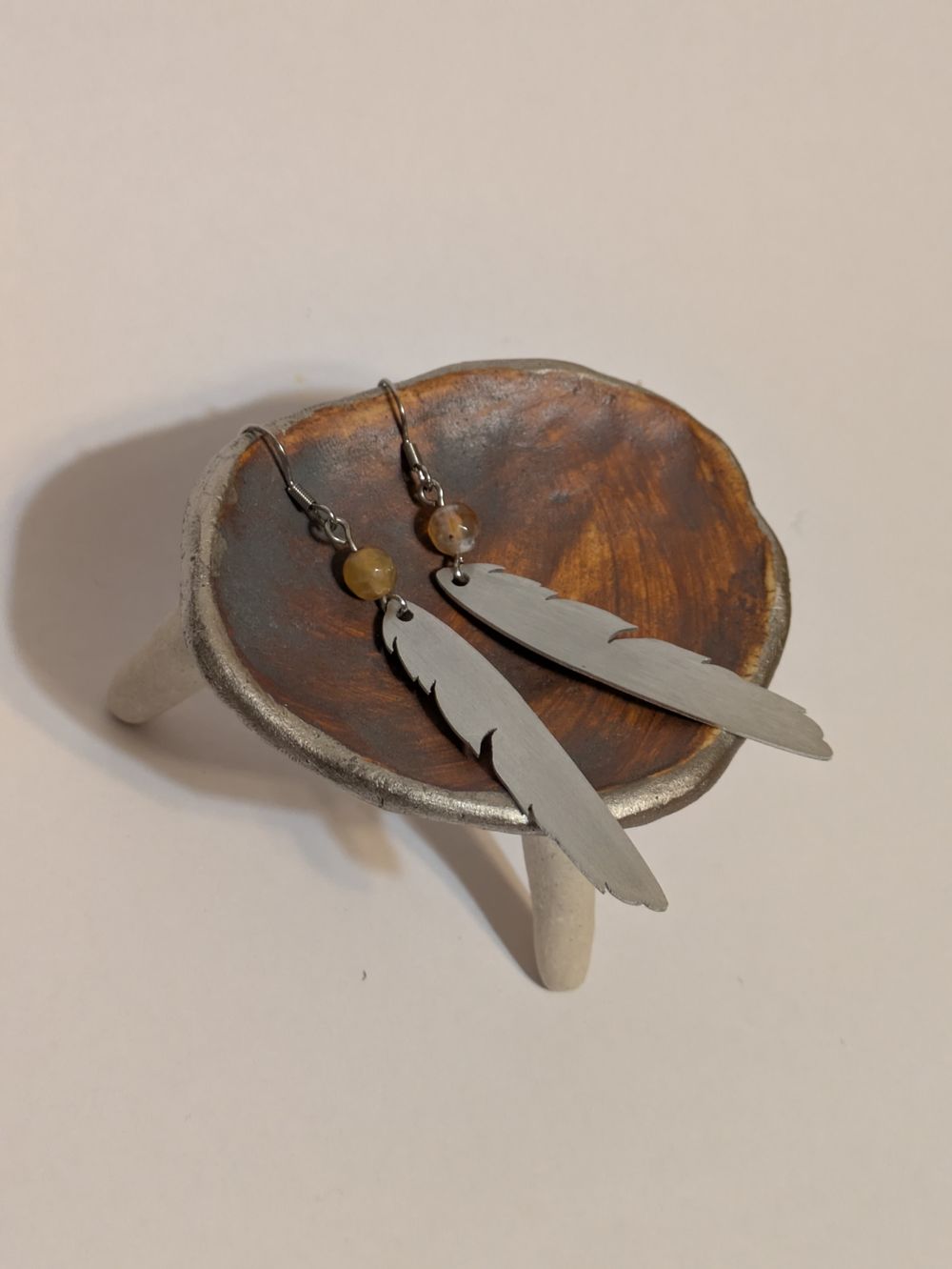 Metal feather dangling earring with natural stone bead accent