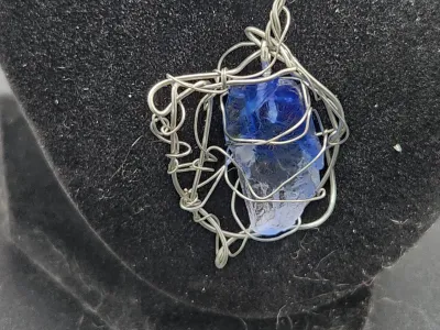 A close up image of the blue resin crystal wrapped in wire