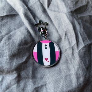 keychain with design based on Uravity’s hero suit, with a multi color star clasp on gray fabric