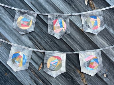 Two strings of patchwork pennant bunting. The top string is Patchwork Pennant #1, the bottom Patchwork Pennant #2