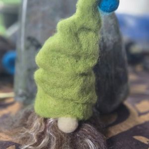 A needle felted gnome with a large green hat