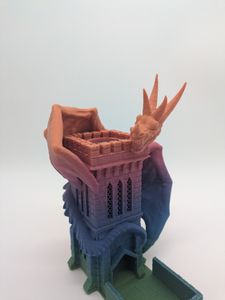 A 3D printed dice tower, depicting a wyvern wrapped around a stone tower. It is printed using a rainbow gradient, starting at green, going to blue, then purple, then orange.