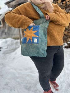 Me wearing the Blue and Orange sawtooth star tote bag with my hand in the pocket