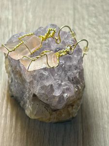 Earrings displayed on a piece of Amethyst.