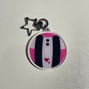 keychain with design based on Uravity’s hero suit, with a multi color star clasp on white tabletop
