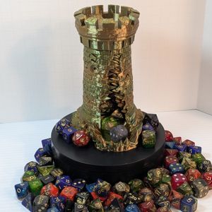 A 3D printed dice tower in the shape of a standard stone tower. This tower is in a shiny earth-tone filament, and has a large gaping maw up the side, in between two windows that look like eyes.