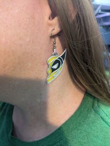 A woman wearing a 3D printed earring that looks like half of a heart. It is styled like half of Wolverine's mask, and it has the word "Friends" in small letters at the bottom.