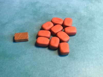 A generic wooden clay/brick token alongside my handmade ones
