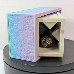 The 3d printed dice tower slash vault. It's laying on its side, partially open, showing how it can store a set of standard size dice.