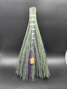 Backside of the broom, which shows more green than purple 