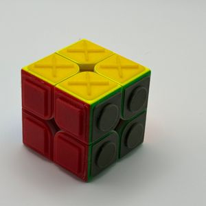 Turn it Tactile 2x2 Speed cube showing yellow Xs, red filled in circles, and green filled in squares
