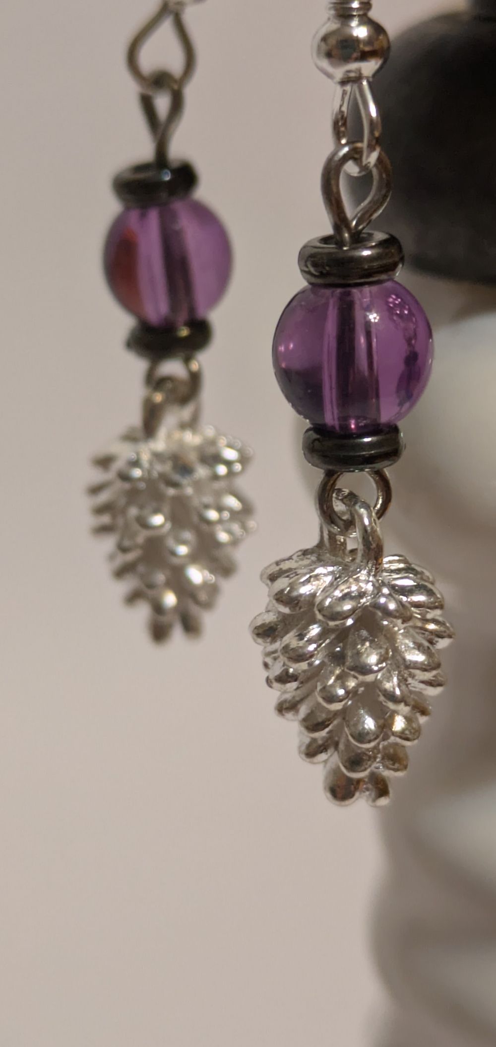Silver pinecone dangling earrings; purple glass beads