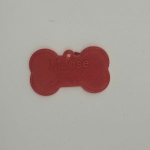 Red dogbone shaped dog tag with the name Mouse in raised print on top and braille below