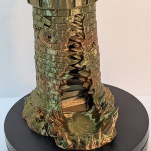 A closer shot of the "face" of the mimic. A toothy maw splits the side, down into a jaw that makes up the dice catching tray. There are stairs coming down the tower, and windows on each side of the maw looks like eyes.
