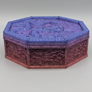 A shot of the tray with the lid on. The filament is sparkly, going from reds to purples to blue. There is a Chinese dragon on the top, with different scenic views around the sides.