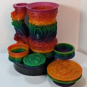 A "tankard" that acts as a dice tower, dice vault, and can holder. It's in a bright rainbow gradient, and it's disassembled to show the dice tower in the handle, the can in the main cavity, the small dice vault at the side, and the screw-on lid.
