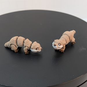 A pair of 3D printed River Otters. They have a hole in the sides of their mouths to hold the earring hook, and they're tan and white in color.