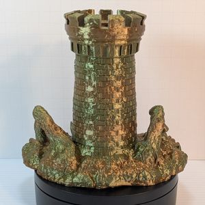 The rear of the tower, which looks like a standard tower with a pair of branches on either side, sticking out of the ground. It shows the shining gradient, going from greens to golds to tans up the tower.