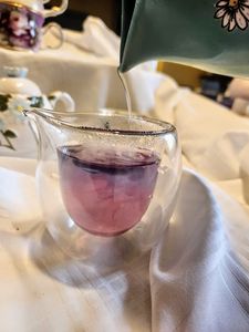 a photo in a glass pitcher of the tea as it starts to change colors