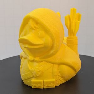 A yellow 3D printed rubber duck inspired piece dressed like a fantasy ranger, complete with a sheath of arrows, a cloak, and leather pouches.