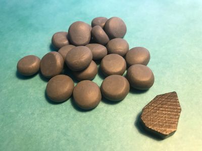 A pile of my stone resources displayed next to a standard board game token