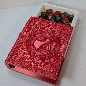 The Fire Magic Dice Tome laying flat, with the pages insert sliding out the top, showing it full of dice.