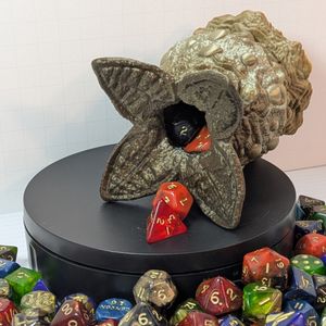 One of the alien eggs, tipped on the side, showing dice coming out of the opening.