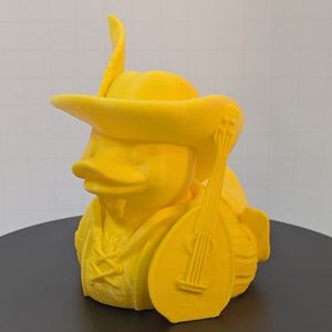 A yellow 3D printed "rubber" duck inspired piece, with a lute at the side, a floppy hat with a feather sticking out, a soul patch, and fancy garb.