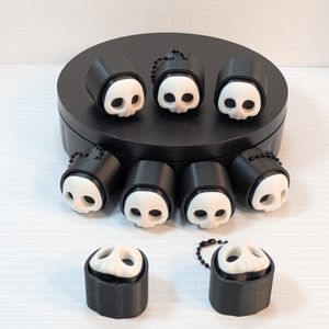 A display of skull clickers, half with chains, half without. They are showing different angles of the clicker.