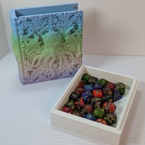 A dice box in the shape of a tome. It's printed in a muted gradient that goes from light blue, green, pink, to purple. On the cover is a face with many tentacles coming out of it. Beside it is the tray, holding at least 2 standard sets of TTRPG dice.
