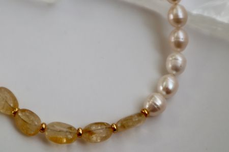 Close up of citrine, freshwater pearl, and galvanized gold beads.