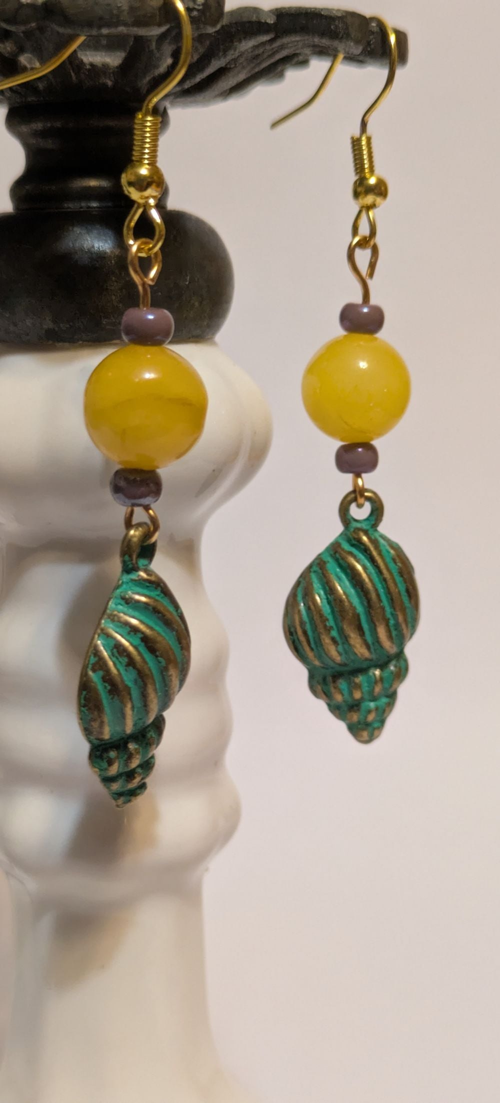Snail shell earrings with yellow glass bead accent