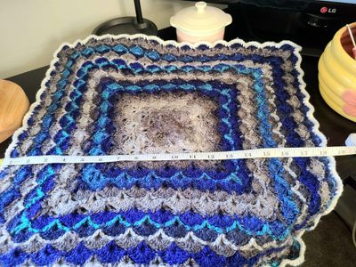 A baby blanket measuring 18inches by 18inches (or 45cmx45cm), in the color Aalborg (06) from the Carnival yarn swatch options. 