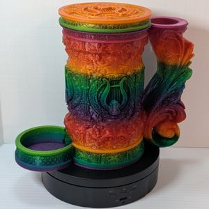 A "tankard" that acts as a dice tower, dice vault, and can holder. It's in a bright rainbow gradient, and it's all assembled, with the tray at the bottom and the lid screwed on the top.