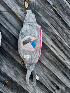 Oval patchwork insert fanny pack hanging against a wall