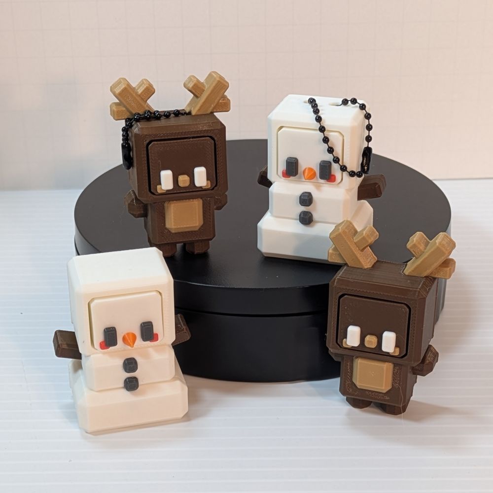 Four squarish character fidget clickers. One is a brown reindeer, the other a snowman. They have separate faces you press, and they click, with cubic heads, bodys, arms, and feet.
